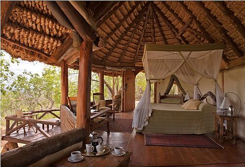 Offenes Schlafzimmer mit Himmelbett und herrlicher Aussicht auf den afrikanischen Busch