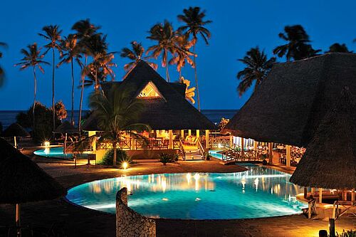 Pool und Gemeinschaftsbereich des Neptune Pwani Beach Resorts auf Sansibar in romantischer Abendstimmung