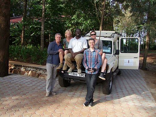 Karibu Safaris Kunden mit Guide vor dem Safari Fahrzeug