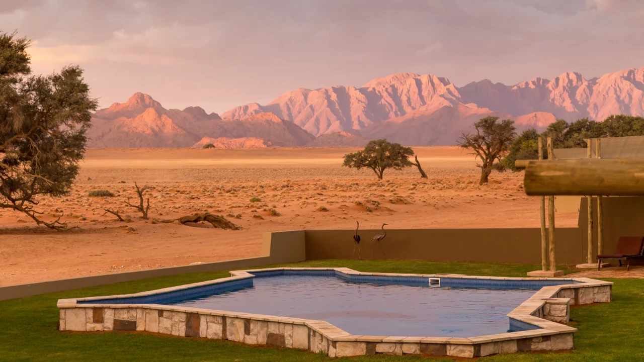 Luxus-Lodge mit Pool am Rand der Namib-Wüste nahe Sossusvlei bei Sonnenuntergang