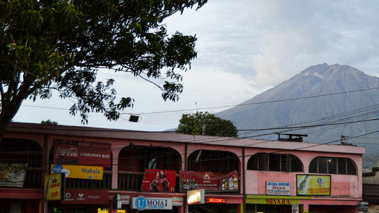 Häuserfront in Arusha vor dem Mount Meru