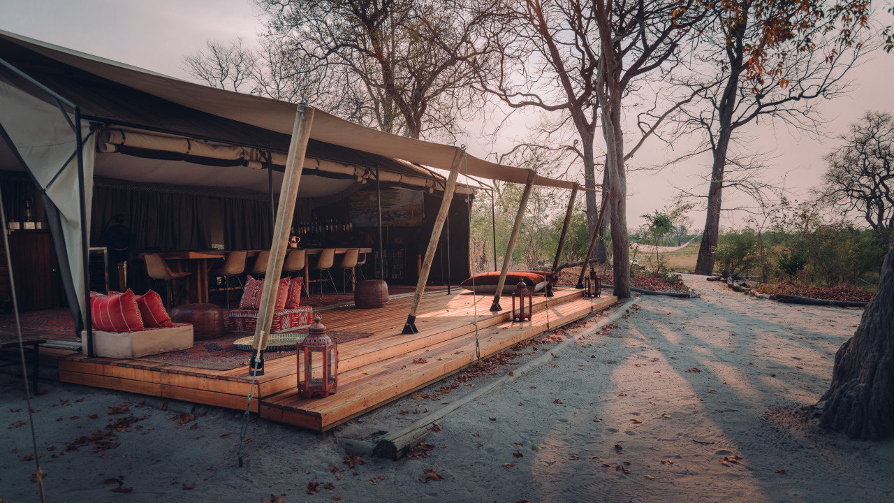 Safari-Zeltcamp in Afrika mit stilvoller Lounge, Holzterrasse und Blick in die unberührte Natur