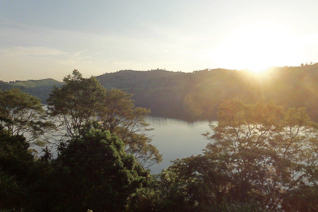 Hügelige Landschaft mit See im Morgenlicht in Uganda