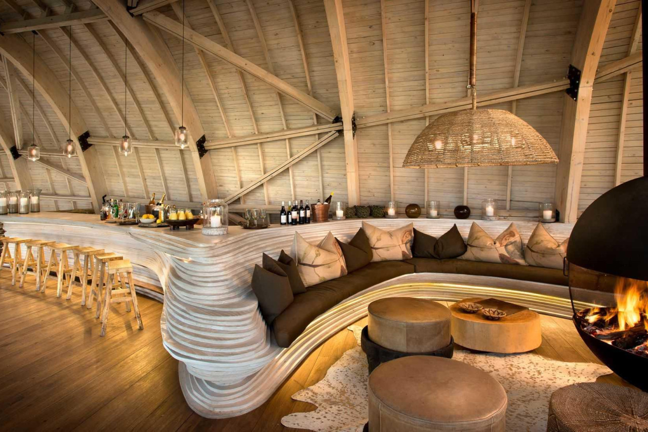 Gemütliche Bar mit Gesprächen am prasselnden Kaminfeuer