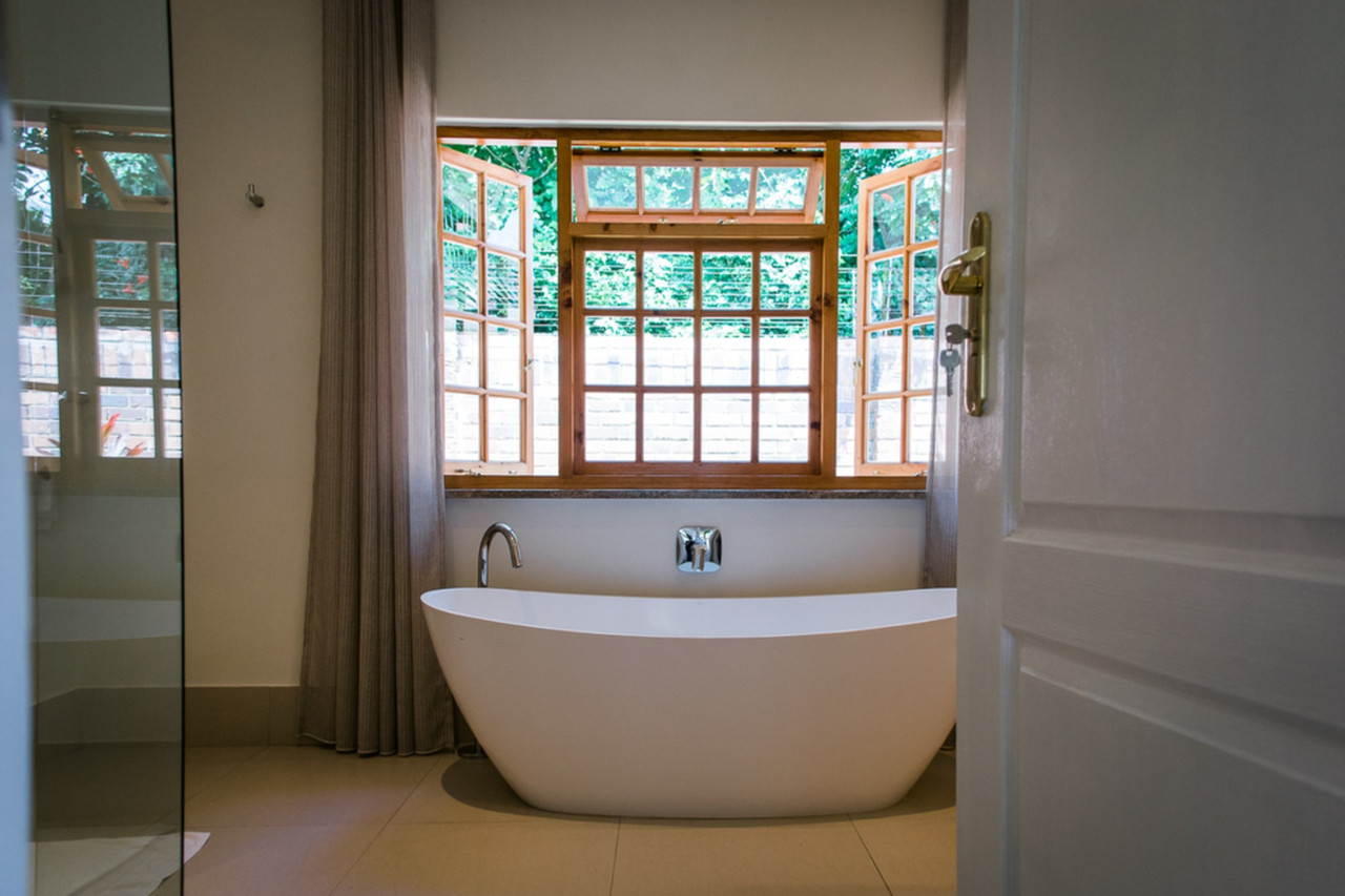 Freistehende Badewanne mit Blick auf Blumengärten