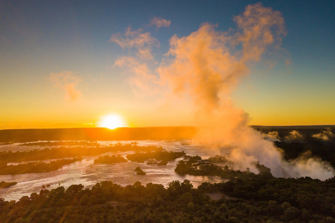 Das tosende Wasser der Victoriafälle trifft auf die Ruhe des Sonnenuntergangs